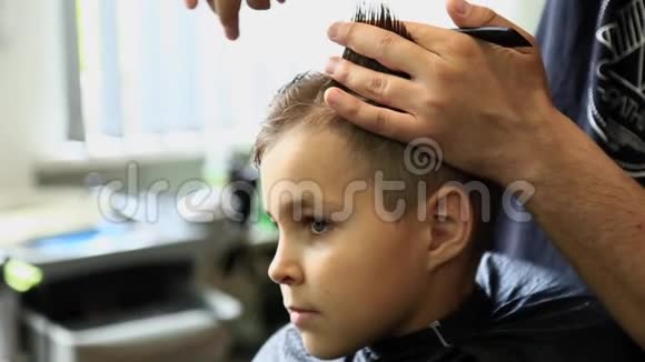 理发师理发的小男孩坐在椅子上视频的预览图