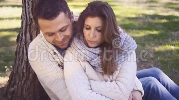 年轻夫妇坐在树下视频的预览图