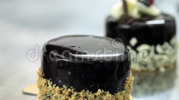 一个糖果师用核桃装饰巧克力单份蛋糕视频的预览图
