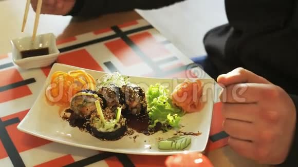 用筷子吃寿司卷的人视频的预览图