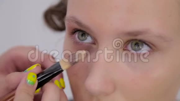 专业化妆师将奶油底眼影底漆应用于模型眼视频的预览图