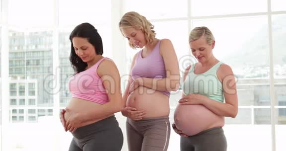 在健身室里对着镜头微笑的孕妇视频的预览图