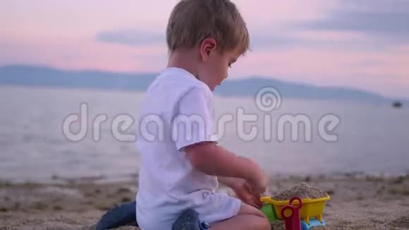 日落时分孩子们在海滩上玩沙子视频的预览图