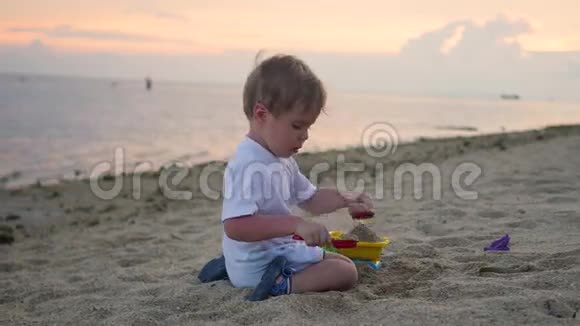 日落时分孩子们在海滩上玩沙子视频的预览图