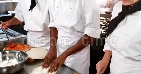 三个厨师在厨房工作视频的预览图