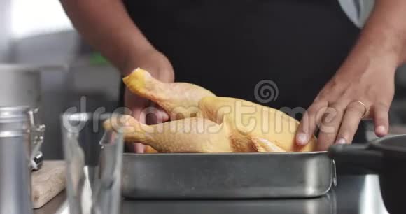 男主厨准备烤鸡和橘子和迷迭香视频的预览图