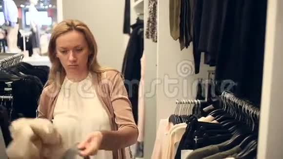 女人在服装店购物挑选衣服视频的预览图
