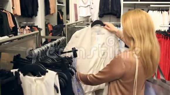 女人在服装店购物挑选衣服视频的预览图