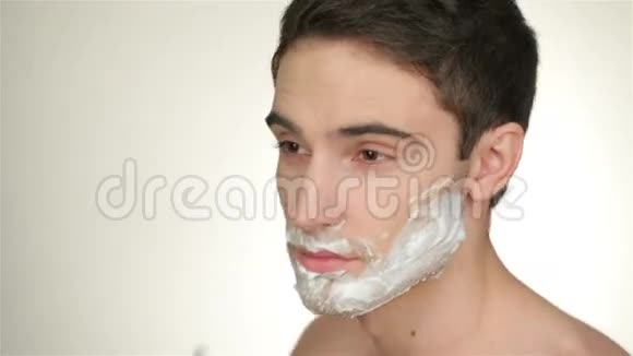 一个英俊的年轻人刮胡子视频的预览图