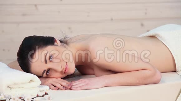 美丽的女孩躺在水疗按摩治疗师视频的预览图