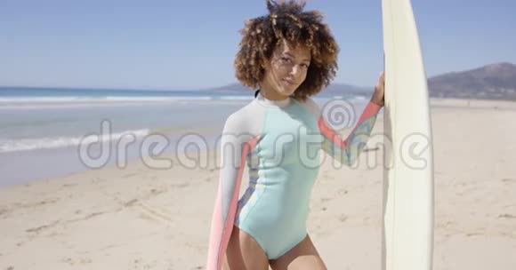 戴冲浪板的女性在塔里法海滩摆姿势视频的预览图