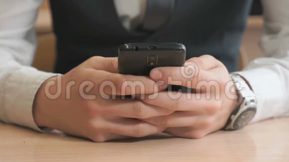 不知名的年轻人拿着黑色智能手机视频的预览图