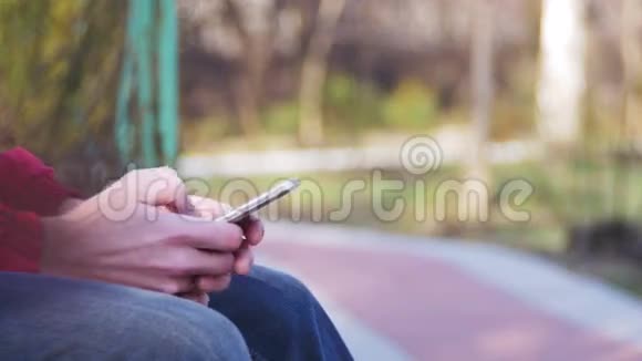 在城市公园的长凳上用手机的年轻人视频的预览图