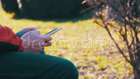 在城市公园的长椅上使用智能手机的年轻人视频的预览图