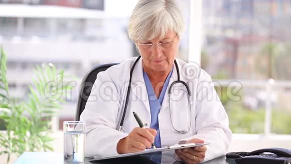 成熟的医生在她的剪贴板上写字视频的预览图