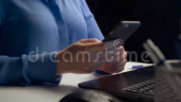 女商人在夜间办公室打电话给智能手机视频的预览图