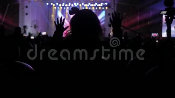音乐音乐会上的人群车削的人群面前灯火辉煌多彩的舞台生活方式的剪影视频的预览图