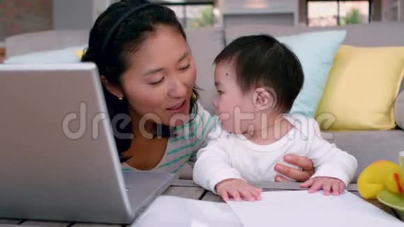 妈妈带着孩子用笔记本电脑视频的预览图
