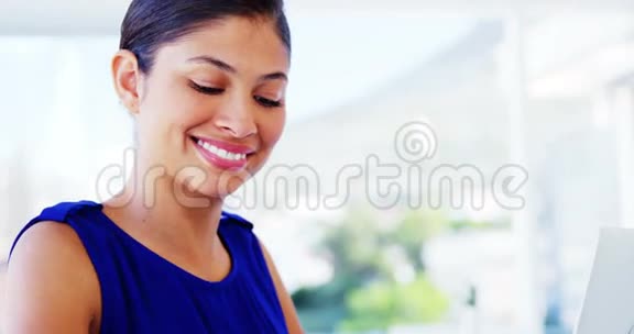 女人微笑着用笔记本电脑视频的预览图