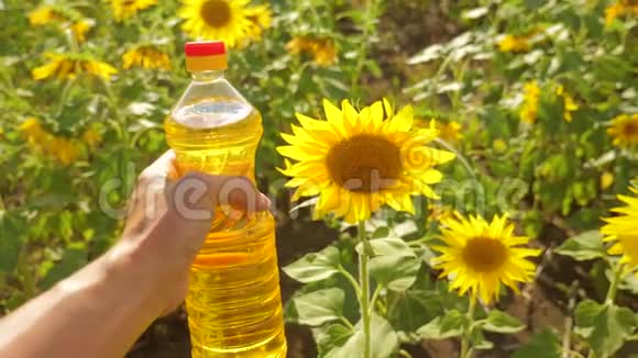 农夫手里拿着一瓶塑料葵花籽油生活方式阳光明媚慢动作视频农业视频的预览图