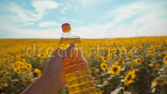 农夫手里拿着一瓶生活方式的葵花籽油手里放着阳光慢动作视频蓝天视频的预览图