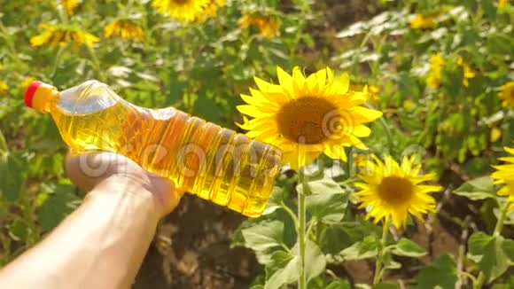 农夫手里拿着一瓶塑料葵花籽油在阳光下生活慢动作视频农业视频的预览图