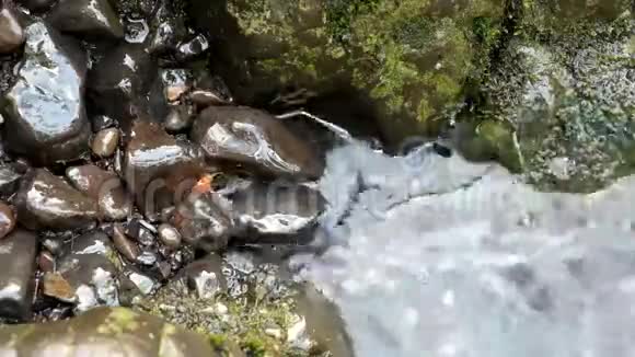 山涧模糊水中的彩色玄武岩视频的预览图
