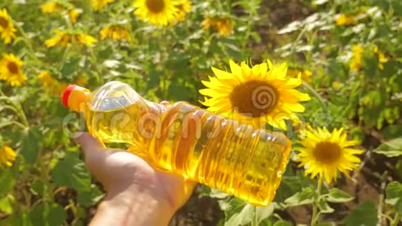 农夫手里拿着一瓶塑料葵花籽油阳光洒在他的手里生活方式慢动作视频农业视频的预览图