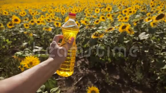 慢动作录像日落时分农夫手捧一瓶葵花籽油农民农业生活方式视频的预览图