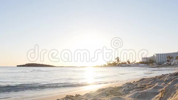 日落时分在沙滩上奔跑的年轻女子视频的预览图