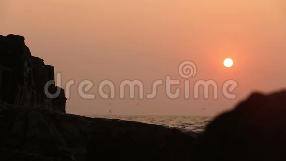 海波背景下日落时的岩石视频的预览图