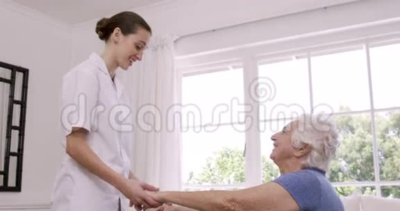 微笑护士帮助老年妇女做运动视频的预览图