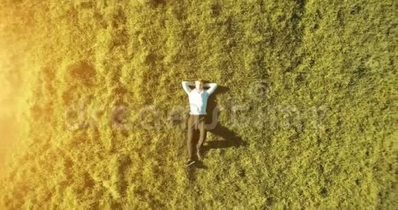 垂直运动飞越商人躺在新鲜的绿色草地上放松的人的最佳景观视频的预览图