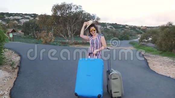 带手提箱的年轻快乐女旅行者视频的预览图