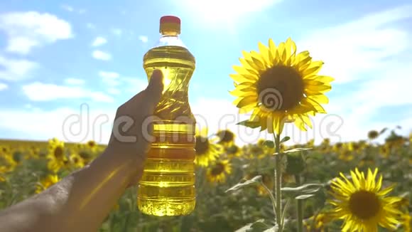 农夫手里拿着一瓶塑料葵花籽油生活方式野外阳光慢动作视频农业视频的预览图