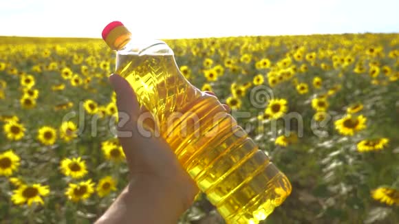 农夫手里拿着一瓶塑料葵花籽油阳光洒在他的手里慢动作视频农业概念视频的预览图