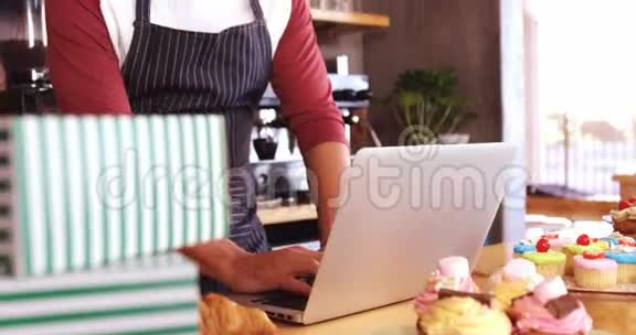 服务员在柜台上用笔记本电脑视频的预览图