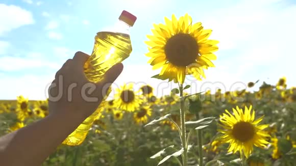 农夫拿着一瓶塑料葵花籽油在他的生活方式手里的阳光慢动作视频农业视频的预览图