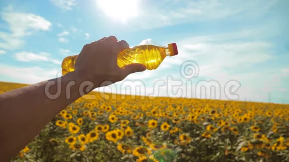 慢动作录像日落时分农夫手捧一瓶葵花籽油农民农业塑料视频的预览图