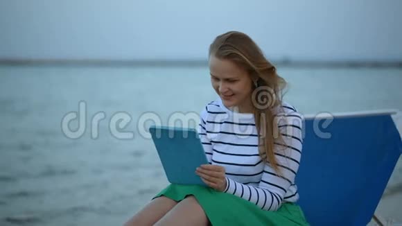在海边有触摸板的女人视频的预览图
