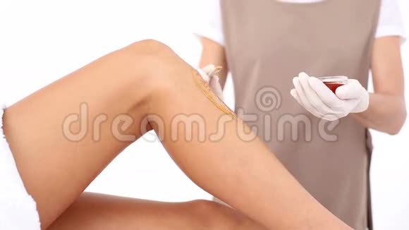美容师在水疗中心给妇女的腿打蜡视频的预览图
