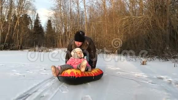 爸爸把女儿推到橡皮充气雪管上视频的预览图