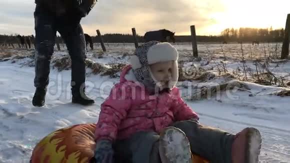 爸爸把女儿推到橡皮充气雪管上视频的预览图