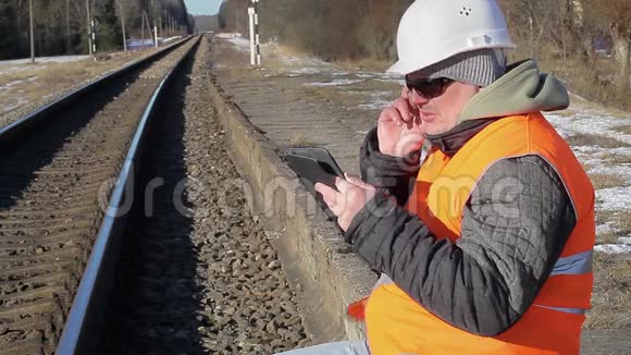 铁路员工在铁路附近用手机交谈视频的预览图