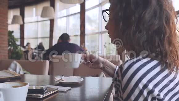 女商人在咖啡馆里喝咖啡视频的预览图