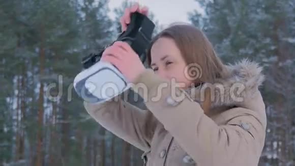 冬天森林里戴虚拟现实眼镜的女人视频的预览图