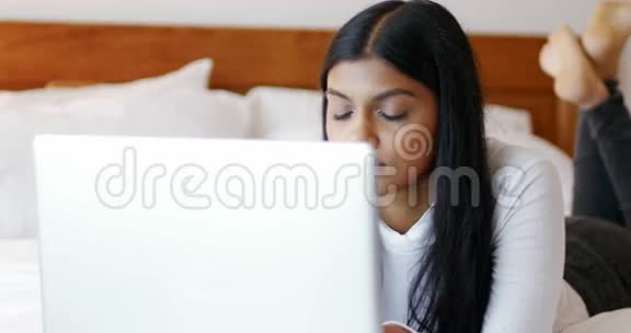 女人在卧室里用笔记本电脑视频的预览图