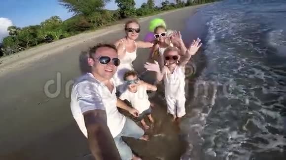 快乐的一家人在白天在海滩上玩气球视频的预览图