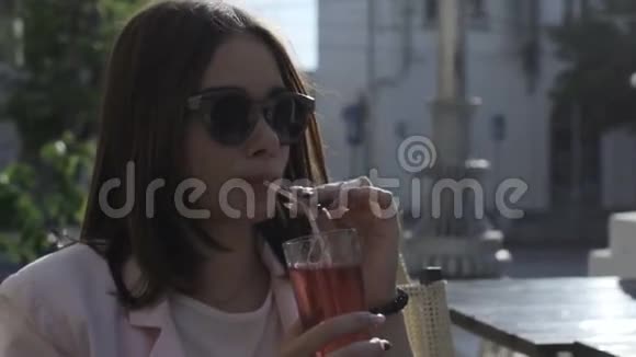 年轻漂亮的女孩在户外喝冷饮视频的预览图