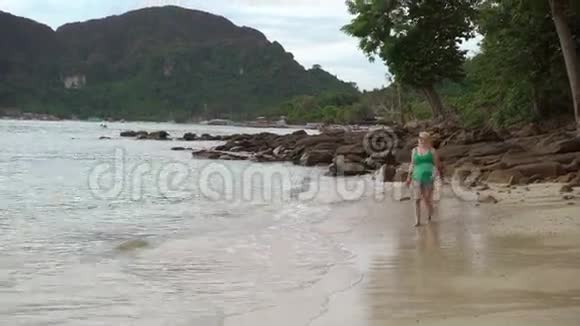 一个女人独自走在狂野的海滩上视频的预览图